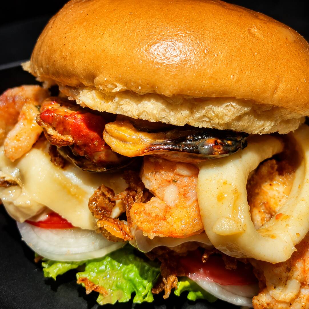 🌊 SEAFOOD BURGER
Pão brioche, filé de peixe crocante, lula , mexilhão e camarão grelhado, catupiry, mussarela, cebola crispy, alface crespa temperada com a maionese da casa, molho rose, tomate e cebola.