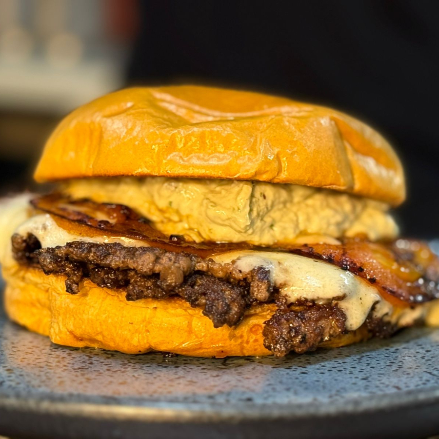 Feito com duas carnes de smash 70g cada, tomate chapeado, queijo provolone defumado e a nossa nova maionese artesanal feita com pesto.