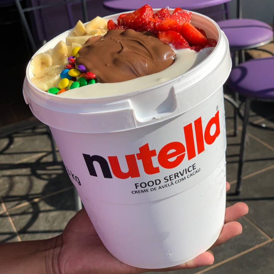 O queridinho das redes sociais na sua casa! O famoso balde gigante de 3kg da Nutella recheado com o nosso açaí artesanal super cremoso. Monte a combinação dos seus sonhos escolhendo seus acompanhamentos, frutas e coberturas favoritas!
⚠️ ATENÇÃO: Servido no balde original da Nutella. Edição super limitada! Perfeito para dividir com a família ou a galera.