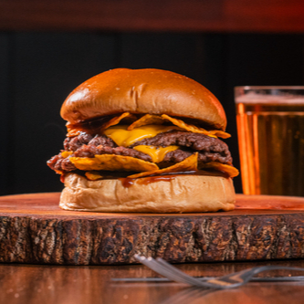 Pão Brioche, 2 Hamburguer Smash (90g) cada, Queijo Cheddar Fatiado, Doritos e Molho de Bacon ou Barbecue.