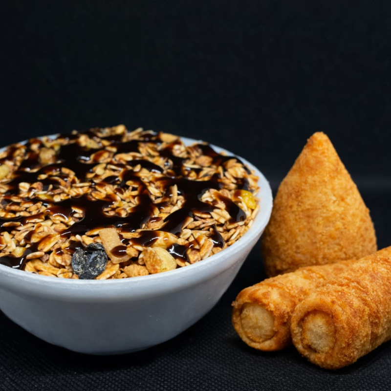O açaí vai acompanhado por: farinha de amendoim, pó de biscoito, granola, banana e calda conforme seu gosto, junto com uma coxinha de frango 60g, 2 enroladinho médio. Combo perfeito para matar a fome e a vontade de doce! 😋