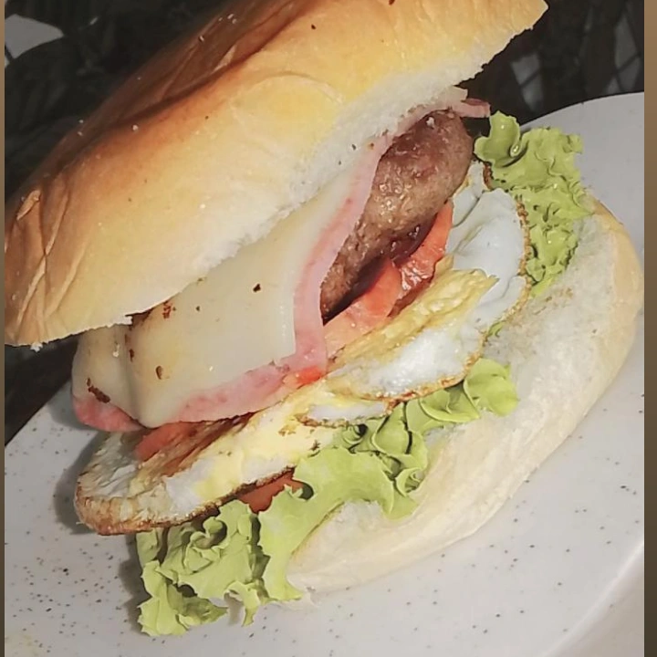 Pão bola 60g, hambúrguer 130g, ovo, queijo, presunto, salada e batata palha.