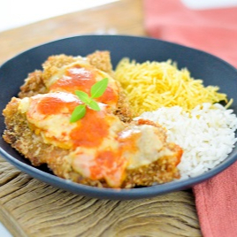 Filé de frango empanado crocante com queijo e molho, acompanhado de arroz e batata palha.