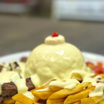Cuscuz recheado com carne seca coberto com creme de queijo, acompanha vinagrete, contra filé grelhado e batata frita