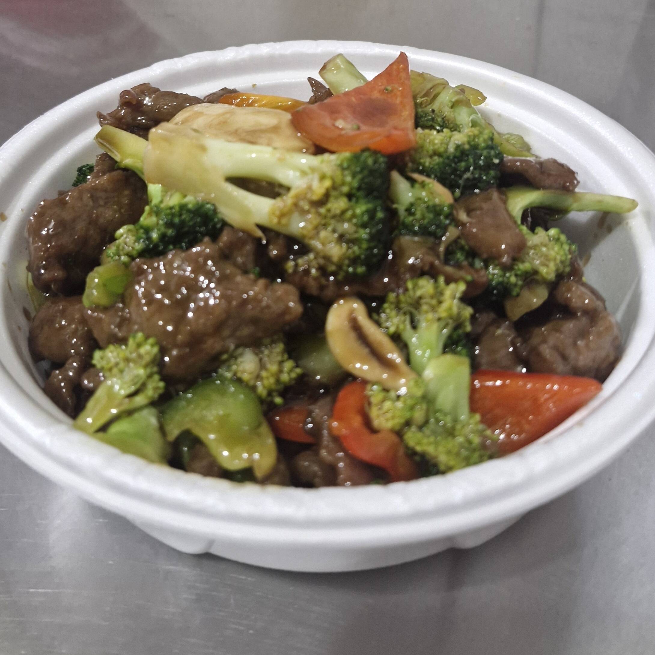 Carne fatiada com brócolis, pimentão verde e vermelho e cogumelo ao molho shoyu.