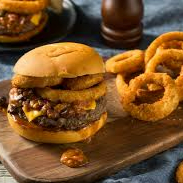 Pão Macio + 2 smash de 60 grs cada vom queijo deliciosamente derretido + molho da casa + 3 anéis de Onion Ring + Molho BBQ + Queijo derretido