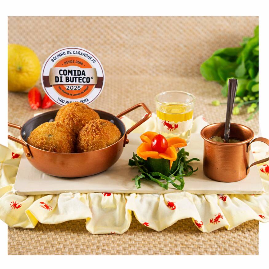 Bolinho de caranguejo, acompanhado por um molho de cebolas frescas com azeite.