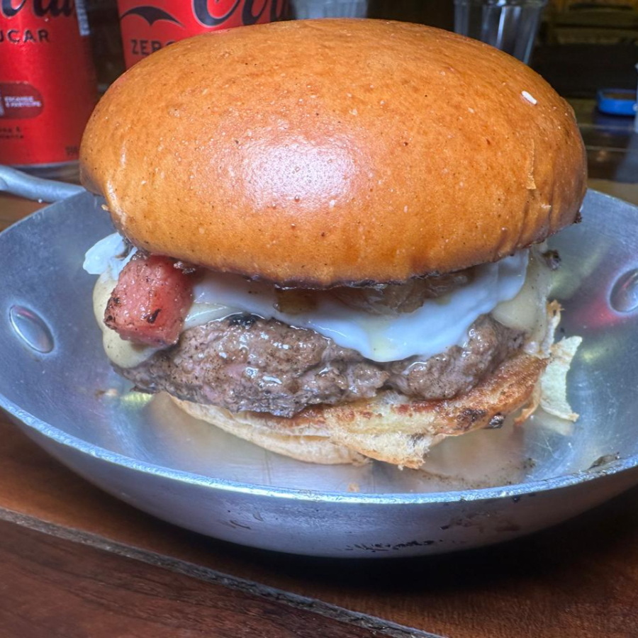 Pão brioche, blend bovino 150g, queijo cheddar, alface, cebola, tomate e maionese da casa.