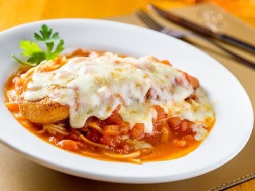 Filé de frango à milanesa envoltos em molho caseiro de tomate fresco e gratinado com queijos muçarela e parmesão. Servido com espaguete no próprio molho.