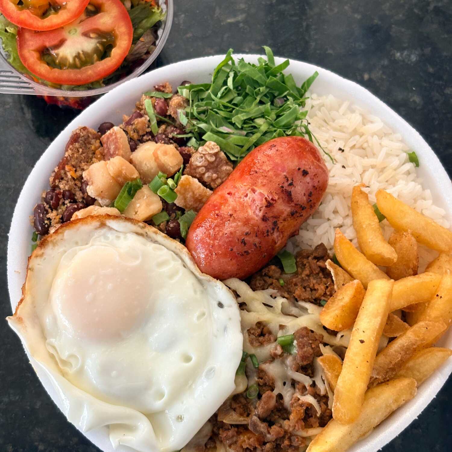Marmita com Arroz, Feijão Tropeiro, Torresmo, Couve, Cebolinha, Macarrão a Bolonhesa com mussarela, Batata Frita, Ovo e Linguiça.