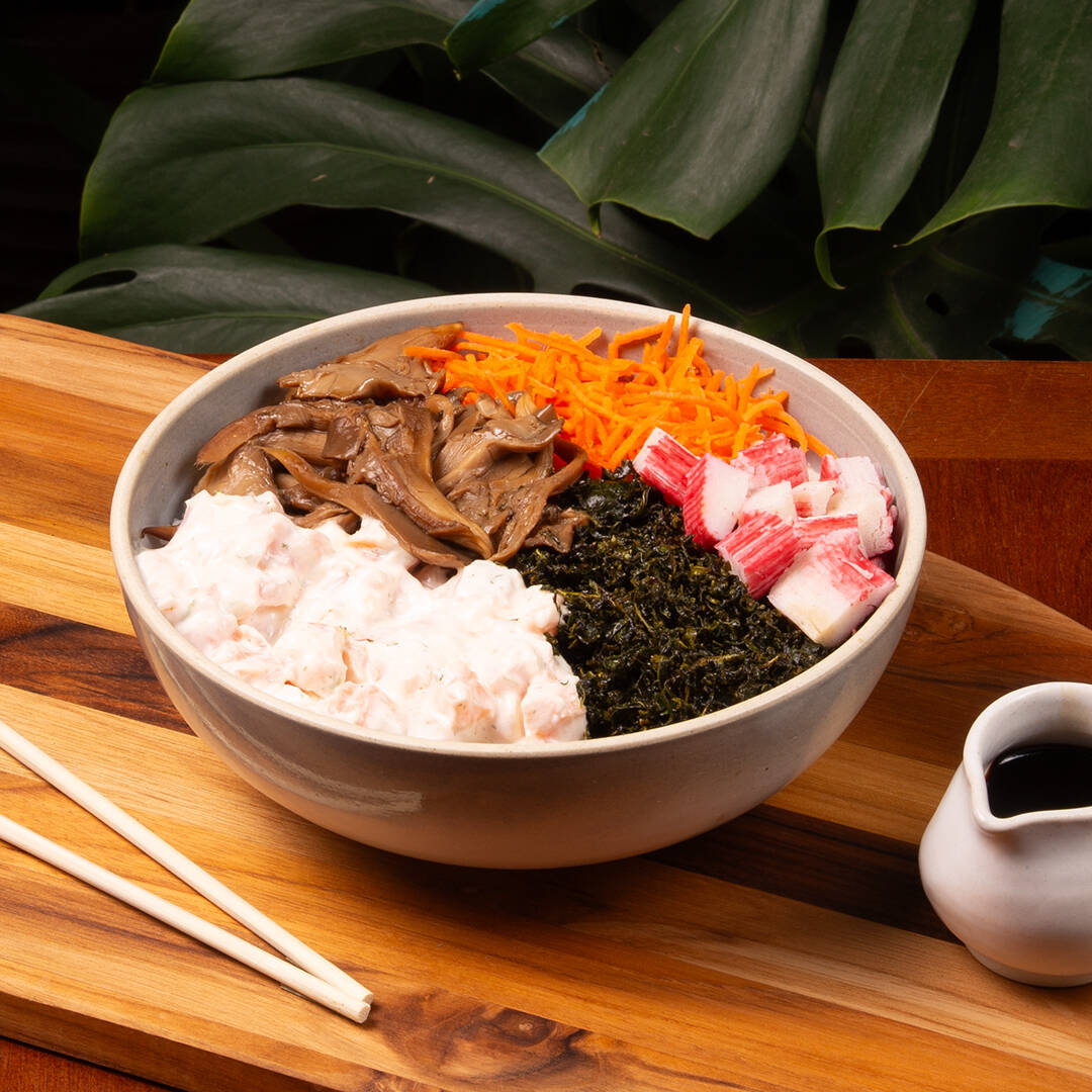 Salmão com cream cheese da casa (com toque especial de dill), arroz japonês temperado (shari), shimeji, cenoura, crisp de couve, kani e molho ponzu. Não é possível trocar nenhum ingrediente neste poke.