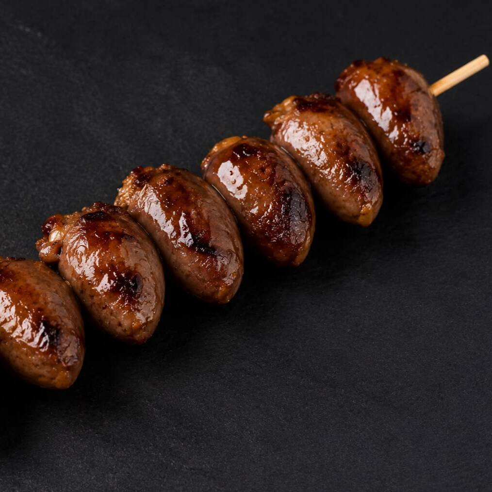 Corações de frango temperados e grelhados no espeto, perfeitos para um churrasco saboroso.