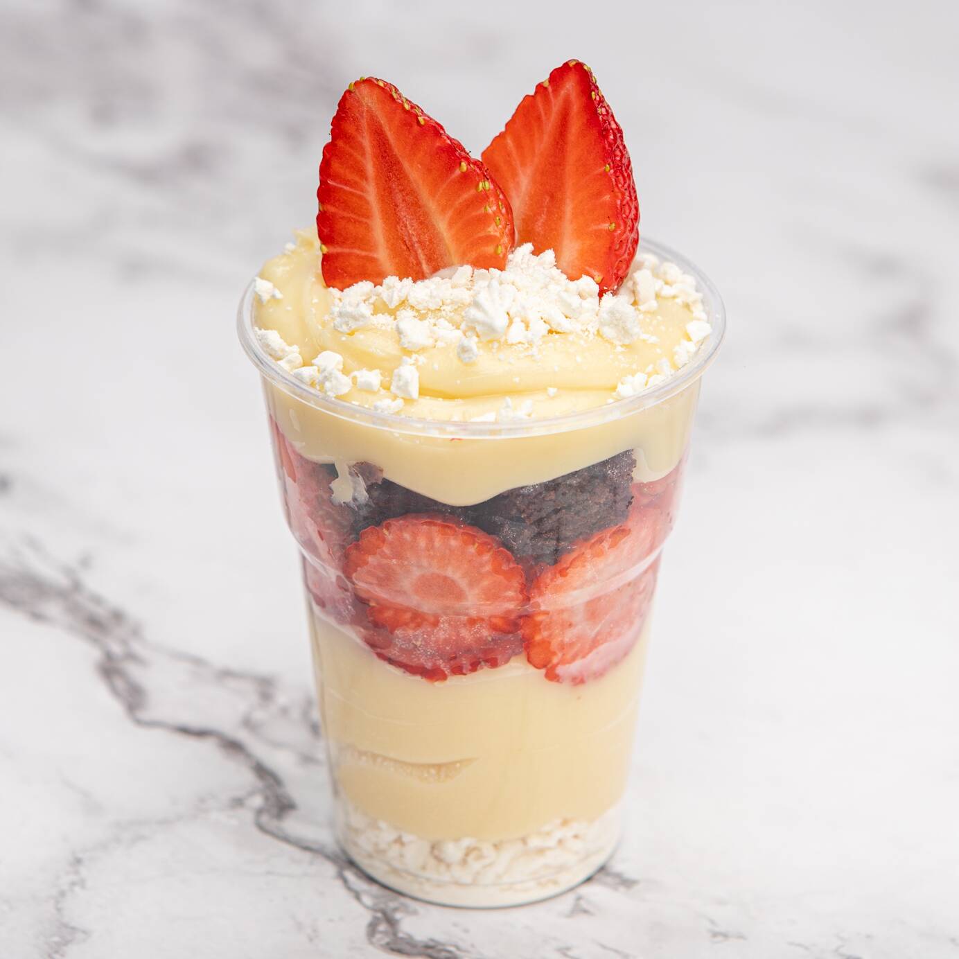 Delicado, cremoso e irresistível! Começa com uma camada crocante de suspiro, seguida do nosso creme de Ninho super aveludado, morangos frescos e doces, pedaços de brownie tradicional e mais brigadeiro de Ninho. Finalizado com morango e suspiro para dar o toque perfeito de sabor e textura