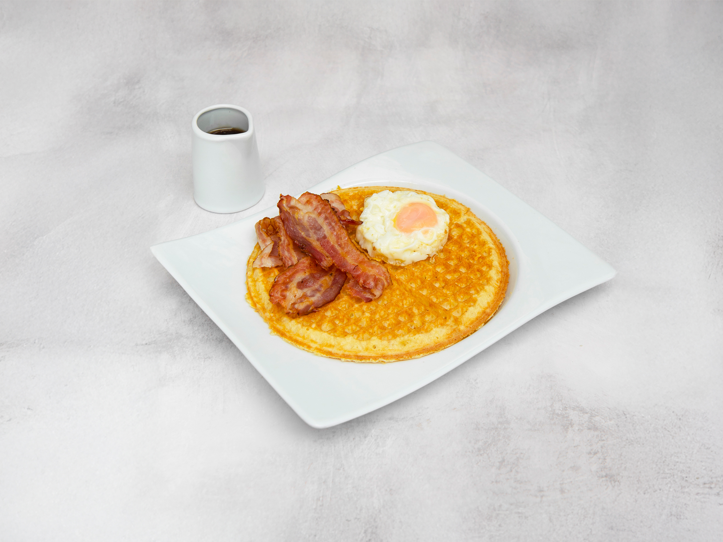 Waffle syrup, huevo frito y tocineta.