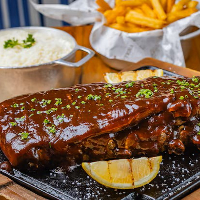 Costelinha suína assada lentamente até ficar macia e suculenta, coberta com nosso molho barbecue artesanal, levemente adocicado e defumado. Acompanha arroz soltinho, batatas fritas crocantes e salada fresca. Uma explosão de sabor em cada garfada!