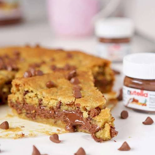 Nossa torta feita com massa de cookie tradicional de baunilha, gotas de chocolate meio amargo e chocolate ao leite, recheada com Nutella.
400g