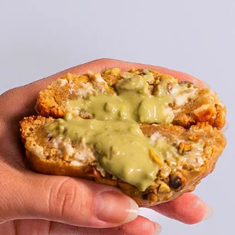 Massa caseira de cookie, recheada com creme de pistache gourmet e finalizado com gotas de chocolate branco e grãos de pistache.