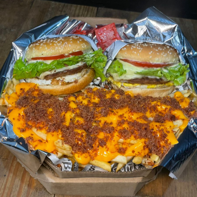 2 x-burgueres, cada um com 1 carne, ovo, queijo derretido no vapor, salada, molho de ervas ( acompanhado de 350g de batata frita com cheddar cremoso e farofa de bacon