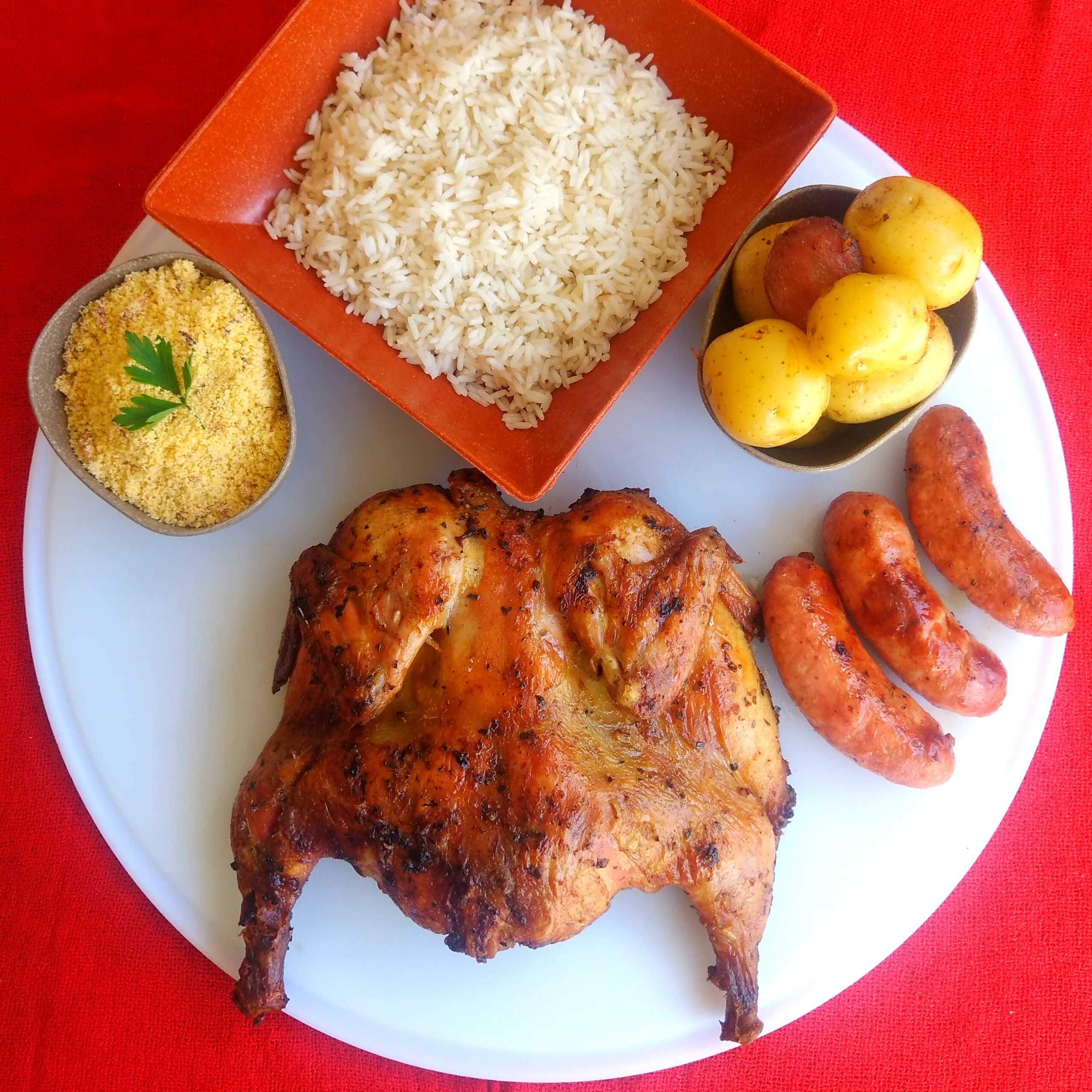 Combo completo pra quem não brinca em serviço: frango assado com farofa, batata, linguiça e arroz soltinho. É comer rezando!
