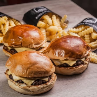 Três Hambúrgueres Smash 100g Suculentos com Cheddar Cremoso e Molho Especial da Casa, Acompanhados de Três Porções de Fritas Mccain Surecrisp Super Crocantes.
