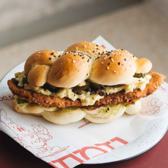 Filé de frango empanado com gergelim, patê de ovo com cebola e picles de pepino.