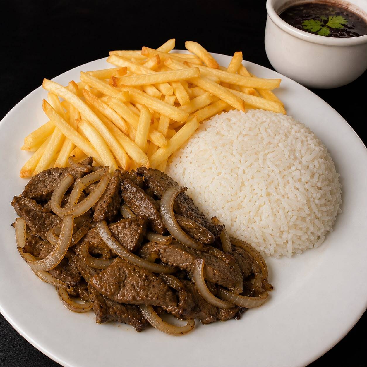 Fígado acebolado bem temperado e preparado na chapa, servido com arroz branco, feijão caseiro e batata frita crocante.