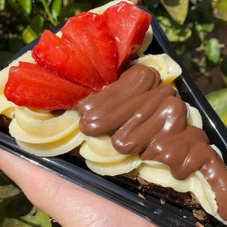 fatia de Brownie Deliciosa com cobertura de Leite Ninho, Nutella e Morango Fresco Aprox. 185g