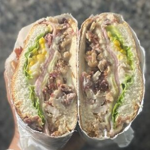 Pão de hambúrguer, frango, bacon, presunto, mussarela, milho, alface e tomate.