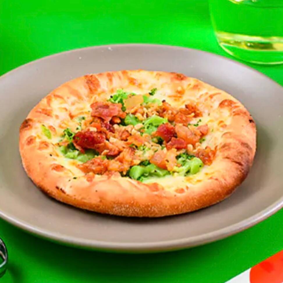 Massa de esfiha assada com mussarela, brócolis, bacon em cubos, requeijão e alho frito, cremosa e saborosa.