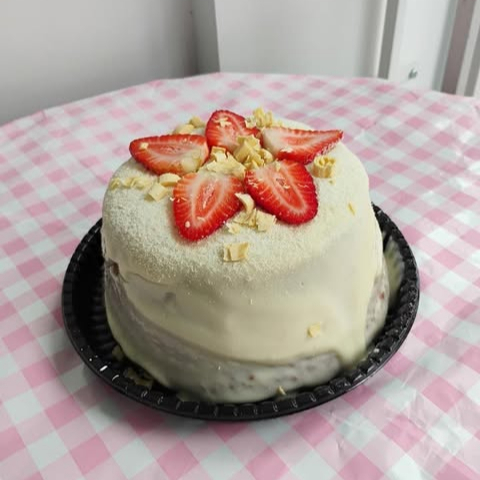 Massa branca deliciosa com recheio super cremoso no meio com brigadeiro branco, e pedaços de morango. e brigadeiro branco em volta, com decoração de raspas de chocolate branco e morango 1kg de gostosura