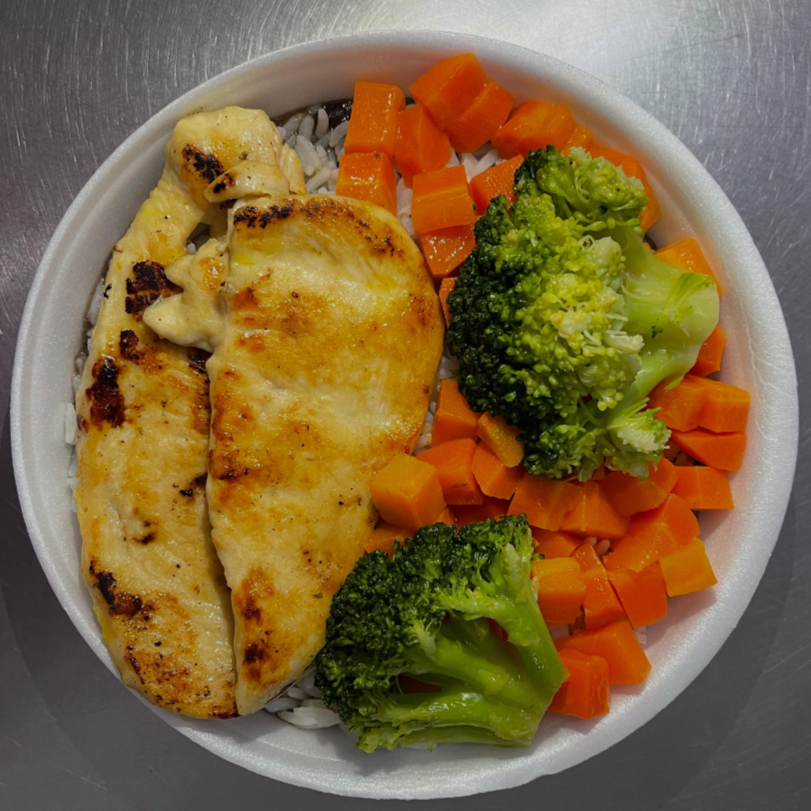 Saboroso peito de frango grelhado, acompanhado de arroz, feijão, brócolis e cenoura.