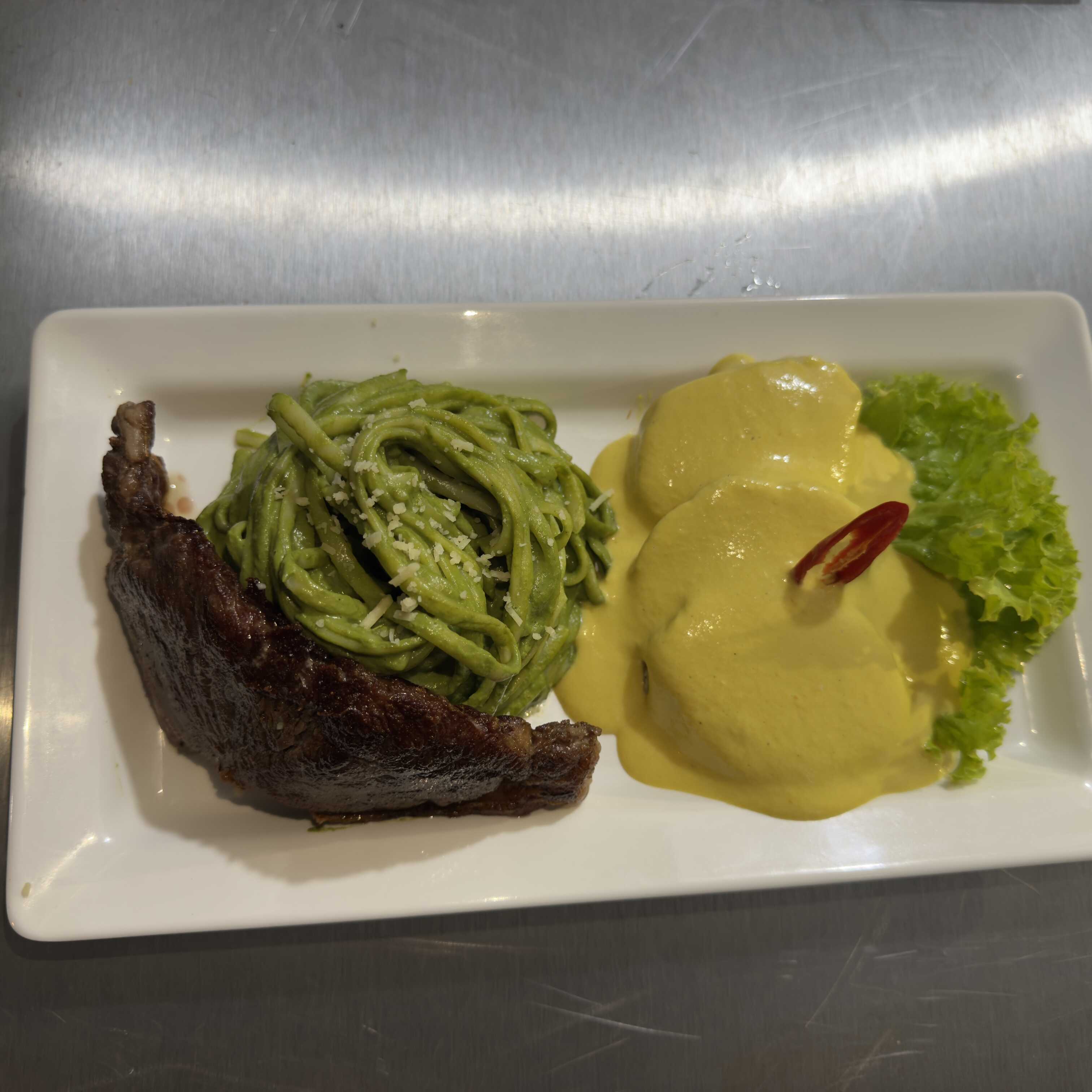 massa ao molho pesto peruano feito com manjerição e espinafre, servida com proteina bife ou frango