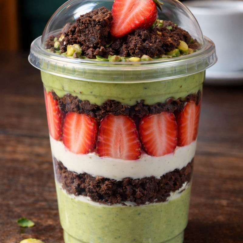 Camadas irresistíveis de creme de nino aveludado, brownie chocolatudo, morangos frescos e um creme de pistache super cremoso. Finalizado com brownie no topo e granulê verde crocante.