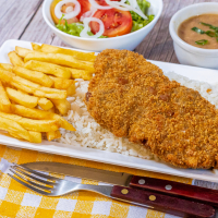 Crocante suculento bife de filé mignon amilanesa acompanhado de arroz, fritas, legumes e feijão separadinhos.