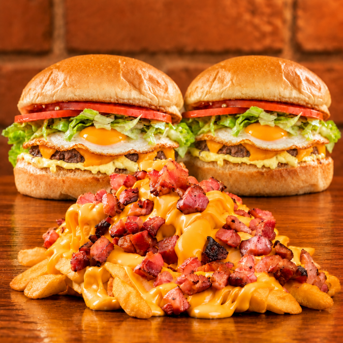 2 Gourmet Especial Samuka (pão gourmet, burguer artesanal 60g, ovo, salada, molho Samuka e cheddar), acompanhados de fritas com queijo, cheddar e bacon(500g). Uma combinação caprichada para dividir!