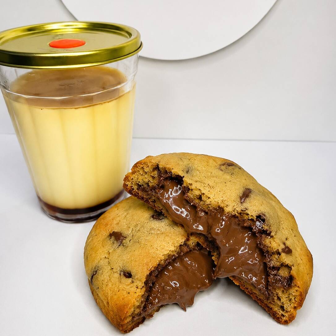A combinação ideal pra quem quer se dar um presente sem exagerar. Um cookie artesanal, macio por dentro e levemente crocante por fora, junto com um pudim super cremoso, feito com leite condensado de verdade e calda caramelizada. O contraste perfeito entre o quentinho do cookie e a cremosidade do pudim — simplesmente impossível comer só uma vez.