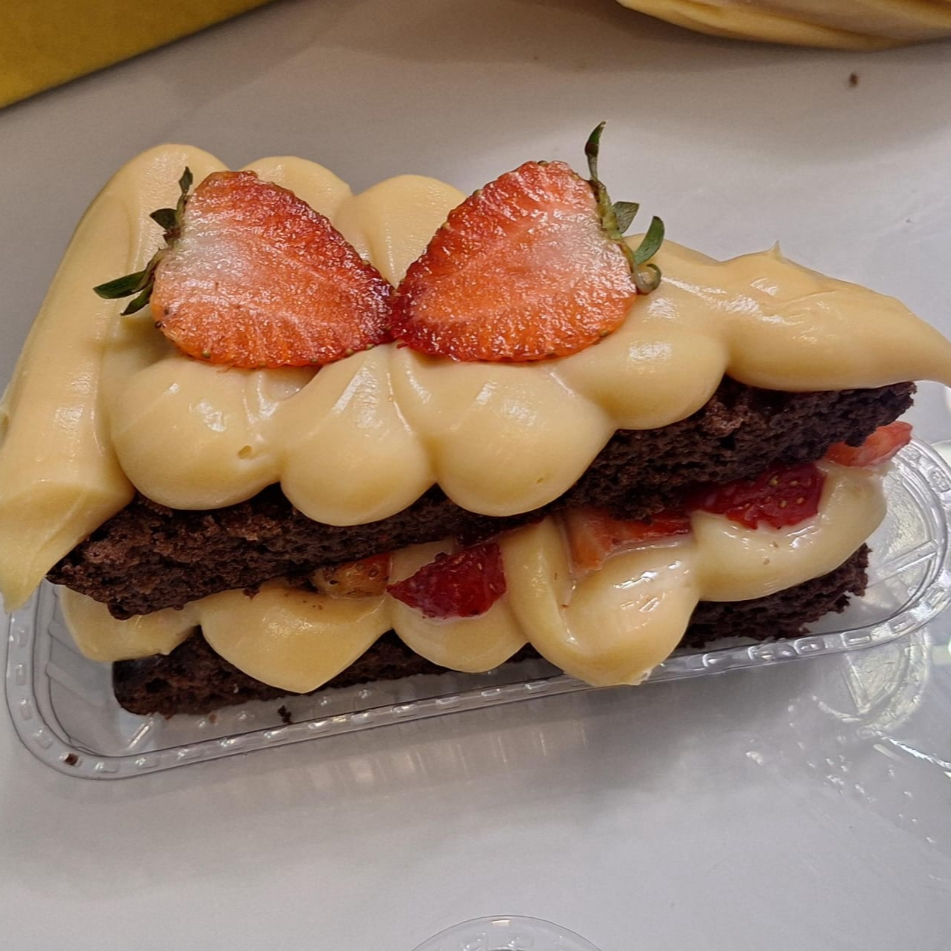 Fatia de Bolo Ninho com Morango 🍓✨ Massa macia e fofinha, recheada com creme de Ninho e morangos frescos, trazendo o equilíbrio perfeito entre cremosidade e frescor. Irresistível em cada fatia! 😍