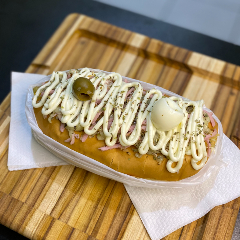 Acompanha: Pão, Salsicha ou Linguiça, Molho, Milho, Ervilha, Molho da Casa, Batata Palha, Cheddar ou Catupiry, Queijo Mussarela Gratinada, Presunto, Orégano e Ovo de Codorna.