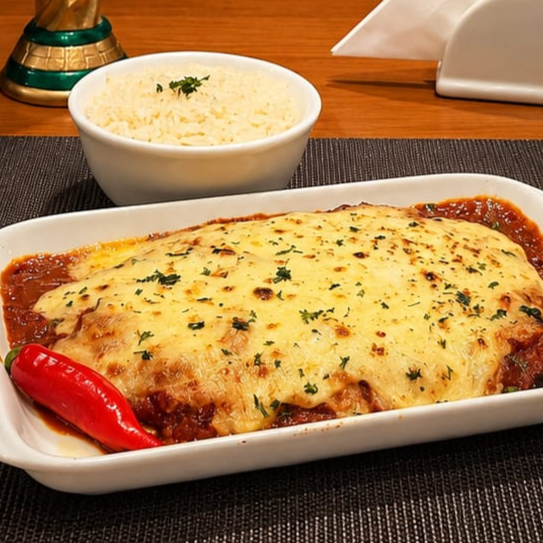 Ojo de bife — o corte mais suculento do boi — empanado na hora, coberto de molho rústico de tomate e muçarela gratinada borbulhando. Vem com arroz soltinho e batatas. Serve até duas pessoas. A parmegiana que não tem cara de delivery.