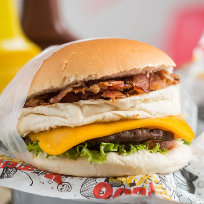 Pão, carne bovina de 55g, presunto, mussarela, ovo, bacon, alface, tomate, milho, batata palha e molho especial.