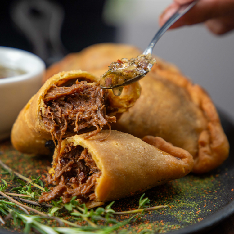 Porção de 3 unidades de empanadas no estilo argentino recheadas com carne bovina deliciosamente temperadas acompanhadas do nosso molho chimichurri da casa.