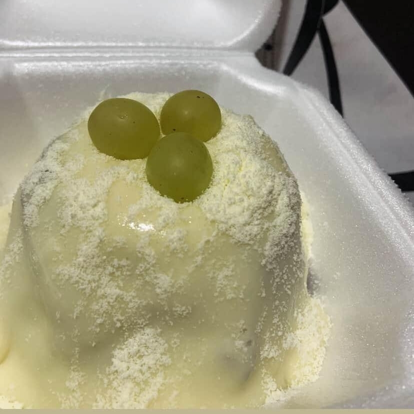 Massa de chocolate, recheio de ninho com uvas por cima é finalizado com leite ninho