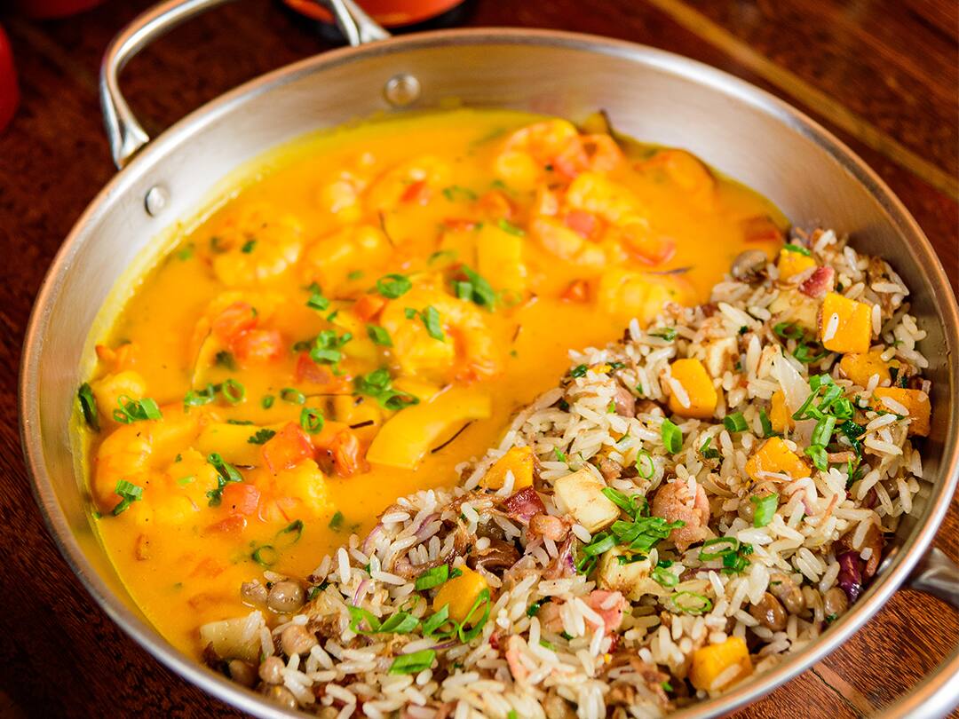 Camarões salteados na cebola e alho, com molho leve de abóbora, leite de coco, tomate em cubos, lascas de coco, coentro e cebolinha. Acompanha baião de dois com carne seca, bacon, cebola roxa, queijo coalho, pimenta biquinho e nata fresca.