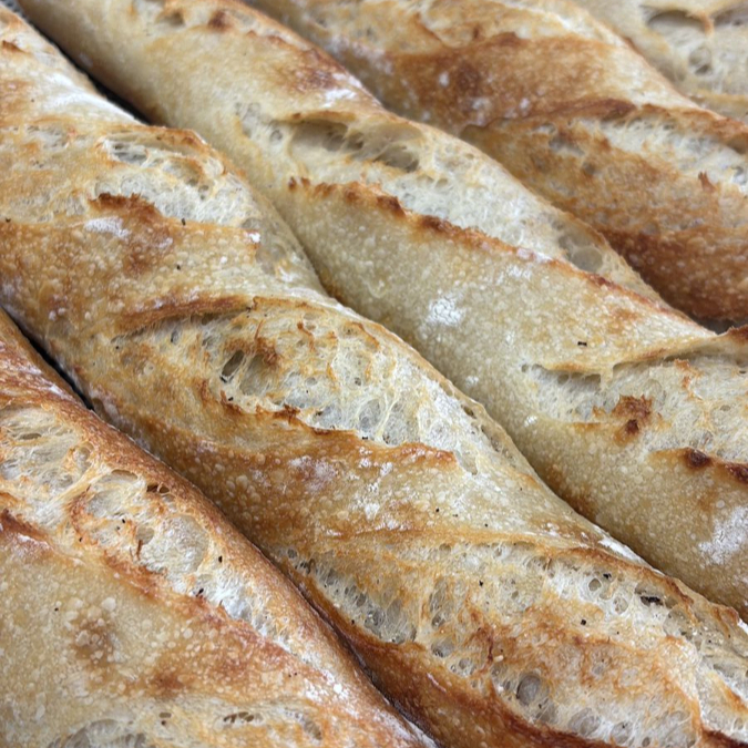 Baguete francesa de fermentação natural, crocante por fora, macia por dentro. Sabor único e textura leva, feita com massa fermentada lentamente e com cuidado.