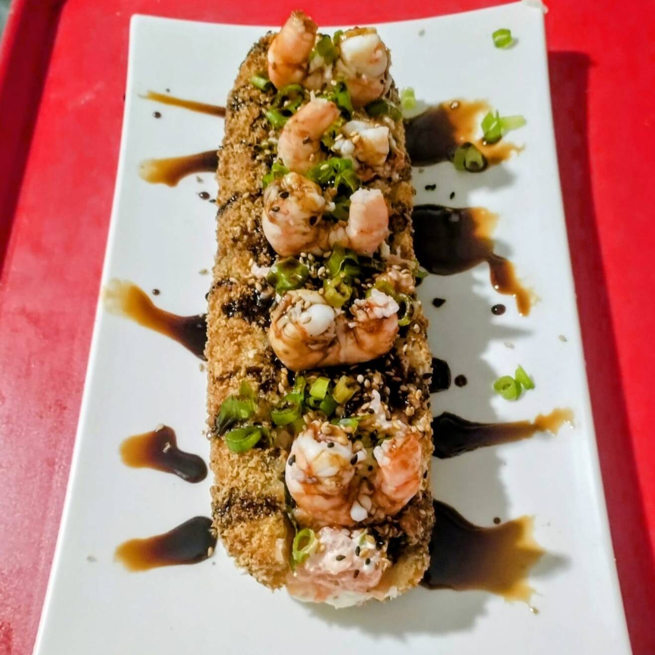 Arroz, cream cheese, gergelim, cebolinha, camarão nautral e pasta de salmão natural envolvido em alga e empanado na farinha panko. Acompanha 2 sachê de shoyu.