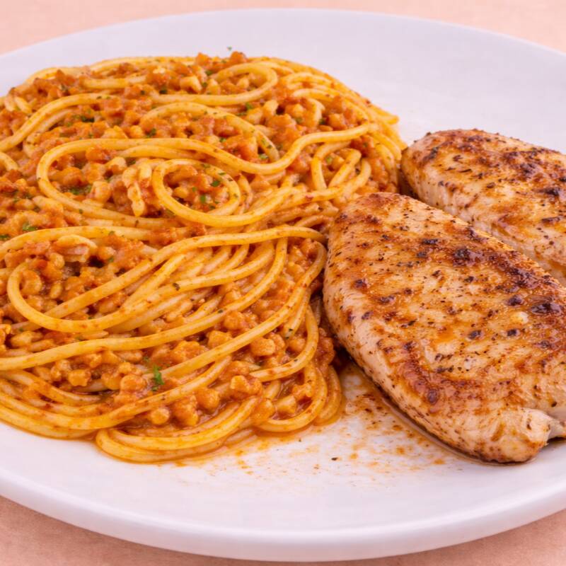 Massa Ao Molho Bolonhesa Suculento, Servida Com Peito De Frango Grelhado Leve E Saboroso.