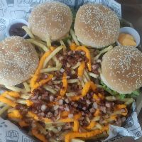 *Quatro X Burguer Duplo*, acompanhado de batata frita com bacon e cheddar, anéis de cebola, molho e um Refri 2 Lts.