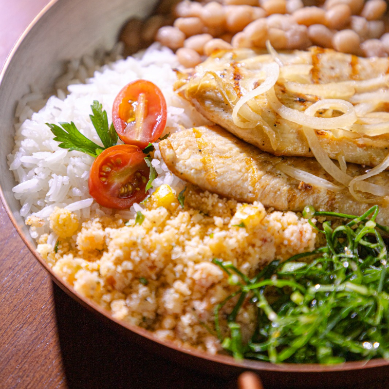 File de frango acebolado, acompanha arroz branco, feijão de caldo, couve refogada e farofa d'água (farinha branca, coentro, manteiga do sertão, tomate, cebola, pimenta do reino).