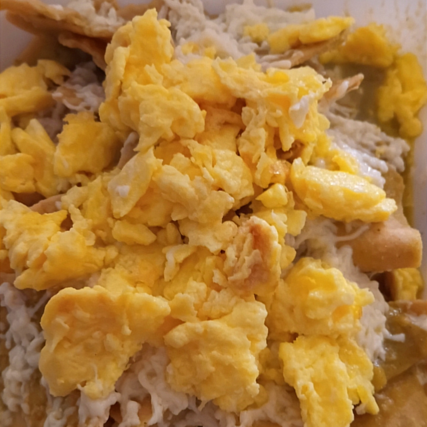 Chilaquiles verdes con huevos revueltos.
