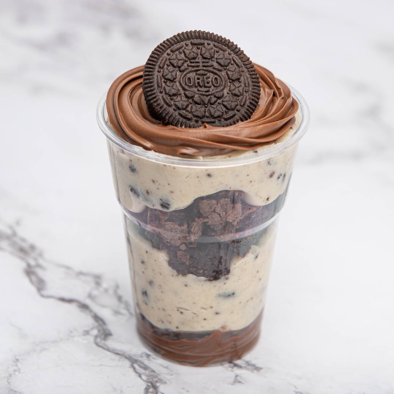 Uma camada de creme de avelã, seguida do nosso cremoso creme de Oreo, pedaços de brownie tradicional bem chocolatudo e mais uma camada de creme de Oreo. Finalizado com creme de avelã e pedaços generosos de Oreo para fechar com chave de ouro.